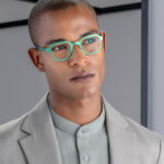 man with green glasses and grey suit