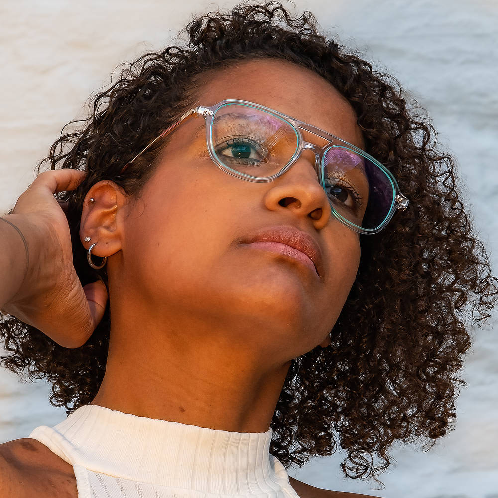 Dame mit schwarzen Locken und blauer Brille